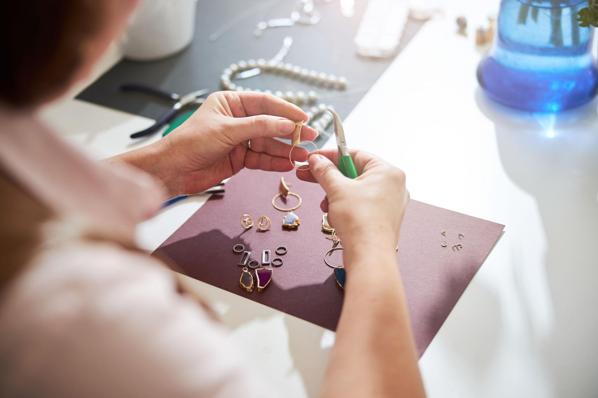 Artisan creating custom earrings in Central Valley by hand using jewelry-making tools.